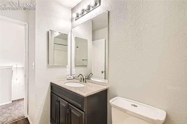 4337 Levi Ln, Colorado Springs, CO 80925 - bathroom with vanity, a textured wall, and toilet
