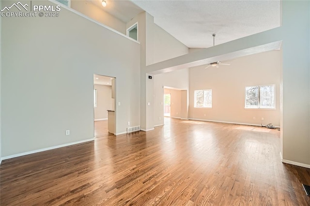 4337 Levi Ln, Colorado Springs, CO 80925 - unfurnished living room featuring a ceiling fan, visible vents, wood finished floors, baseboards, and high vaulted ceiling