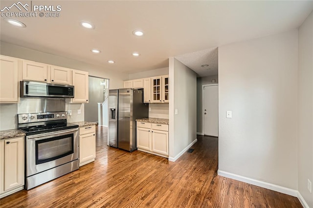 4337 Levi Ln, Colorado Springs, CO 80925 - kitchen with baseboards, glass insert cabinets, wood finished floors, and stainless steel appliances