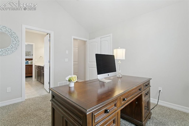 office space with light colored carpet, baseboards, and vaulted ceiling