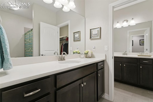 full bath featuring tile patterned floors, a walk in closet, and vanity