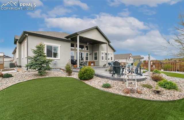 back of house featuring central AC, fence, a yard, a patio, and stucco siding