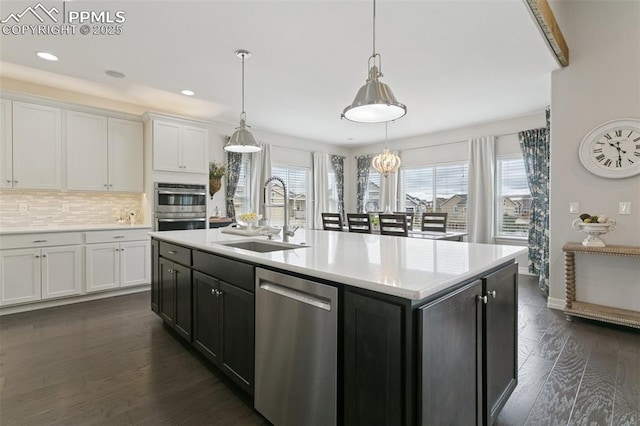 kitchen with a sink, white cabinetry, appliances with stainless steel finishes, and decorative backsplash
