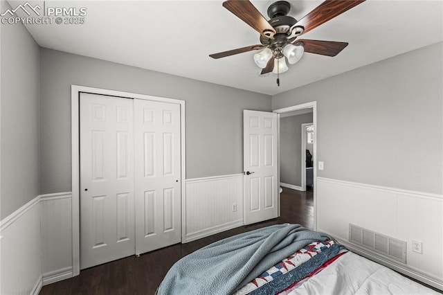 bedroom featuring visible vents, wainscoting, and dark wood finished floors