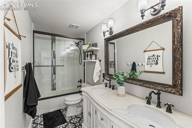 full bathroom featuring toilet, visible vents, a sink, and bath / shower combo with glass door