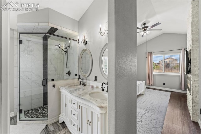 bathroom with a ceiling fan, a sink, lofted ceiling, and wood finished floors