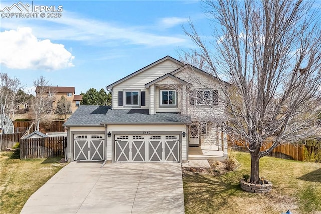 traditional-style home featuring fence, a shingled roof, a garage, a front yard, and concrete driveway