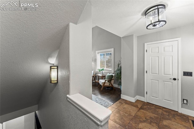 entrance foyer with baseboards and a textured ceiling