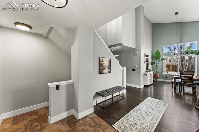 interior space with baseboards, a high ceiling, and an inviting chandelier