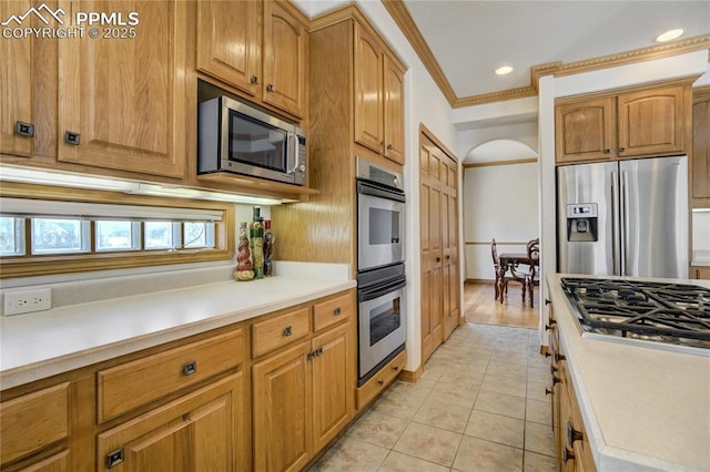 kitchen featuring stainless steel appliances, ornamental molding, light countertops, light tile patterned floors, and recessed lighting