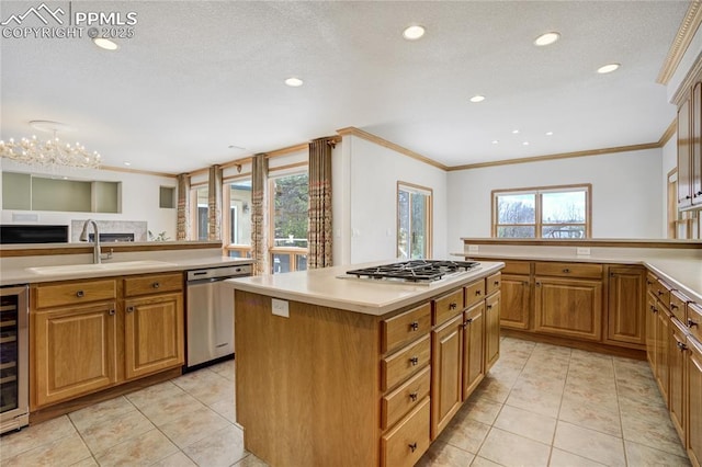 kitchen featuring appliances with stainless steel finishes, a sink, ornamental molding, light countertops, and recessed lighting