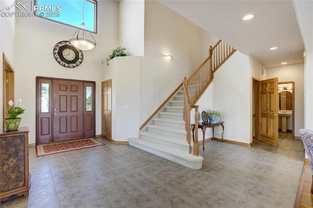 foyer featuring a high ceiling, recessed lighting, stairs, baseboards, and tile patterned flooring