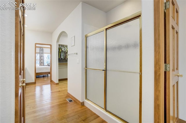 bathroom with wood finished floors, a shower stall, recessed lighting, and baseboards