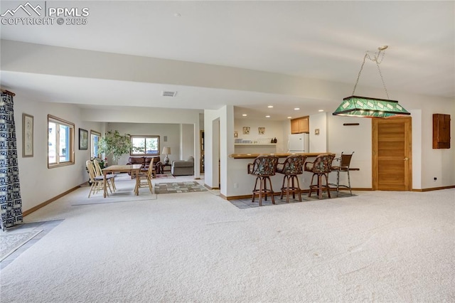 living area featuring light carpet, baseboards, and recessed lighting
