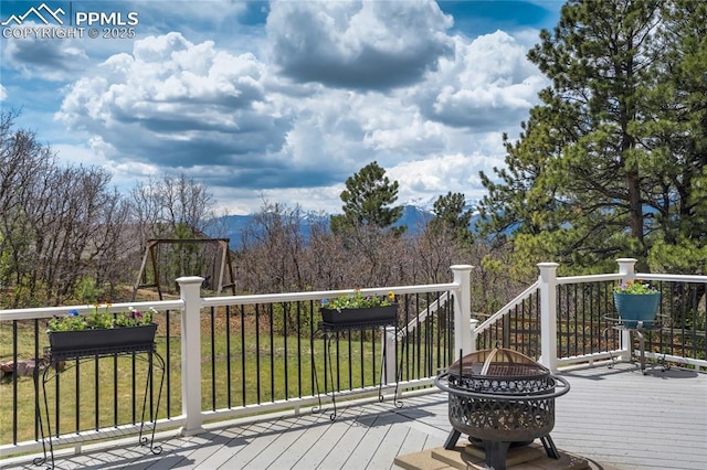 wooden terrace with an outdoor fire pit and a mountain view