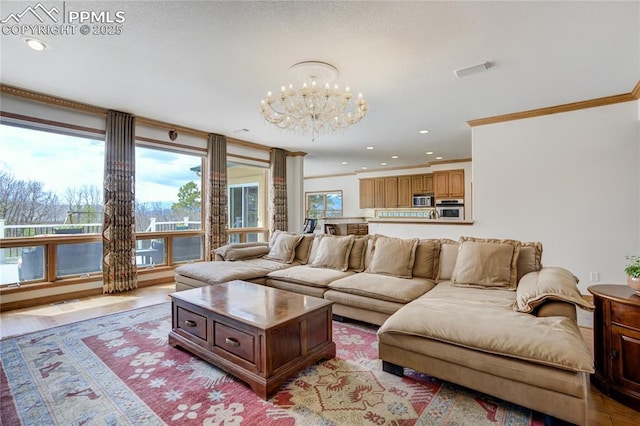living area with ornamental molding, a chandelier, and recessed lighting