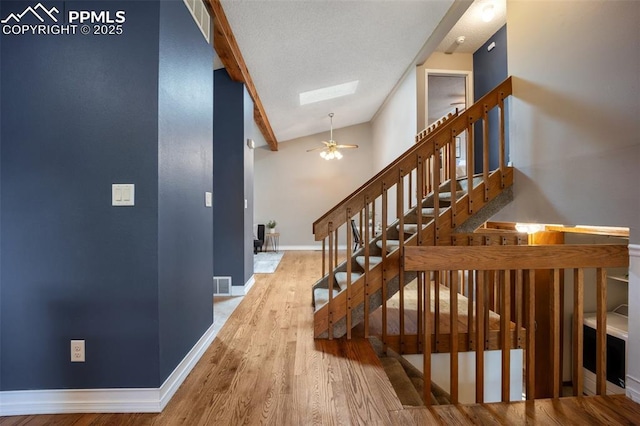 6277 Gunshot Pass Dr, Colorado Springs, CO 80917 - stairway with a skylight, wood finished floors, lofted ceiling, baseboards, and ceiling fan