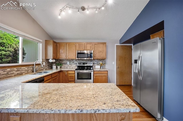 6277 Gunshot Pass Dr, Colorado Springs, CO 80917 - kitchen with appliances with stainless steel finishes, a sink, lofted ceiling, tasteful backsplash, and light wood finished floors