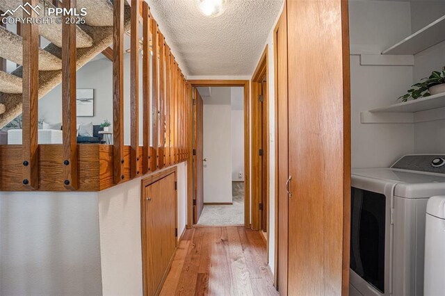 6277 Gunshot Pass Dr, Colorado Springs, CO 80917 - laundry room featuring light wood-style floors, independent washer and dryer, and a textured ceiling
