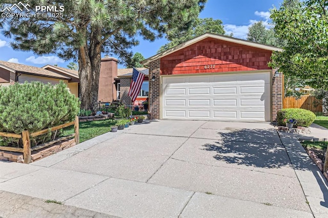 6277 Gunshot Pass Dr, Colorado Springs, CO 80917 - view of front of property featuring brick siding, concrete driveway, fence, and an attached garage