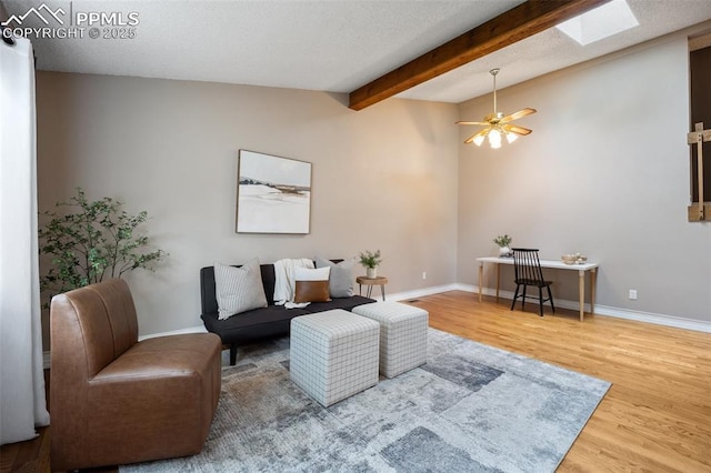 6277 Gunshot Pass Dr, Colorado Springs, CO 80917 - living room with wood finished floors, a skylight, baseboards, beam ceiling, and ceiling fan
