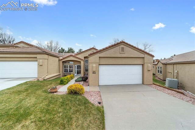 7815 Antigua Pt, Colorado Springs, CO 80920 - ranch-style home with driveway, a front yard, central AC, an attached garage, and stucco siding