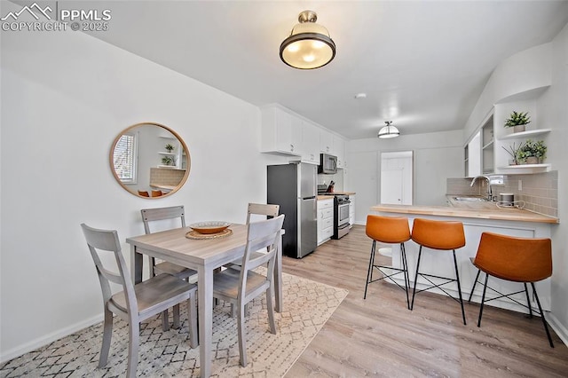137 N 14th St, Colorado Springs, CO 80904 - dining room featuring light wood-style floors and baseboards