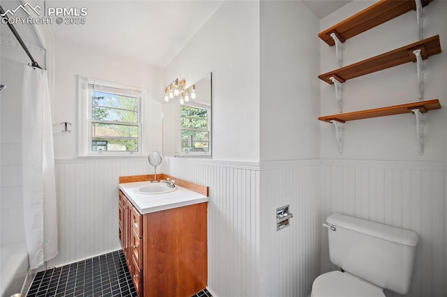 137 N 14th St, Colorado Springs, CO 80904 - bathroom with vanity, tile patterned flooring, wainscoting, toilet, and shower / tub combo