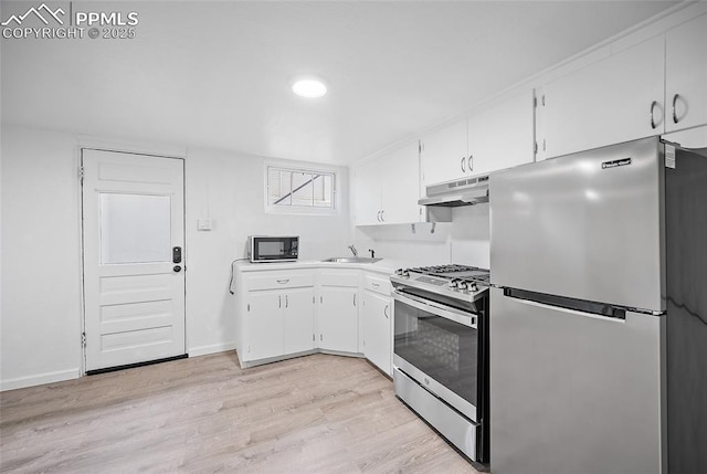 137 N 14th St, Colorado Springs, CO 80904 - kitchen featuring appliances with stainless steel finishes, white cabinets, under cabinet range hood, and light wood-type flooring