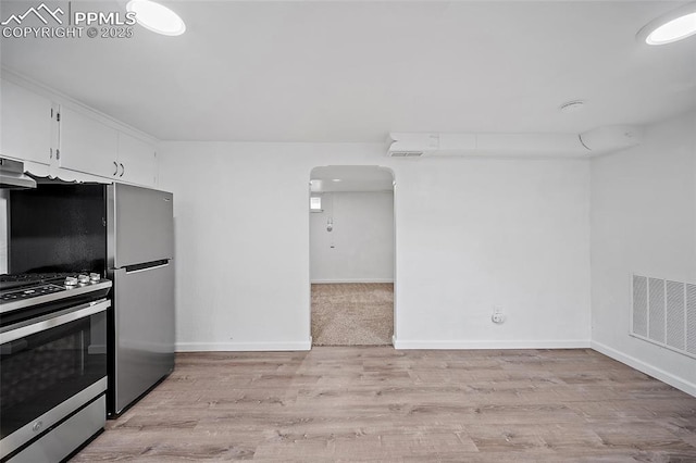 137 N 14th St, Colorado Springs, CO 80904 - kitchen featuring visible vents, light wood-type flooring, white cabinetry, arched walkways, and stainless steel appliances