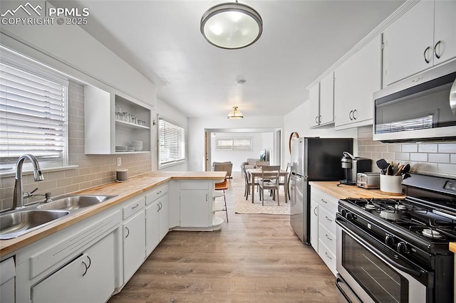 137 N 14th St, Colorado Springs, CO 80904 - kitchen featuring a sink, appliances with stainless steel finishes, a peninsula, and tasteful backsplash