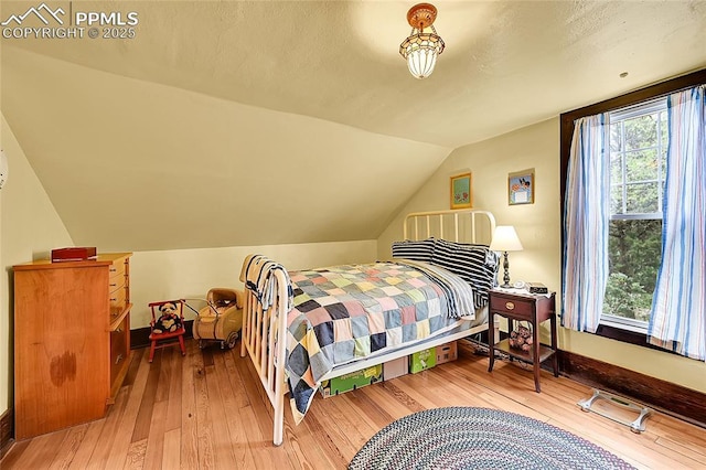 bedroom featuring vaulted ceiling and hardwood / wood-style flooring