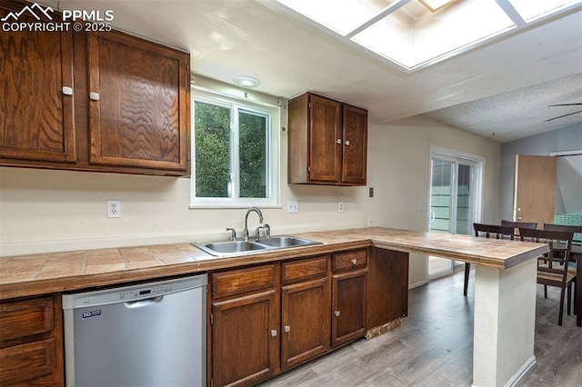 1950 Rusty Hinge Dr, Colorado Springs, CO 80920 - kitchen featuring dishwasher, a sink, tile countertops, and light wood-style floors