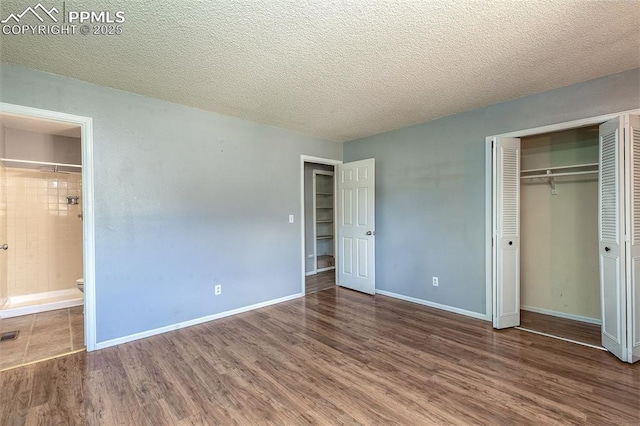 1950 Rusty Hinge Dr, Colorado Springs, CO 80920 - unfurnished bedroom featuring wood finished floors, a closet, ensuite bath, baseboards, and a textured ceiling