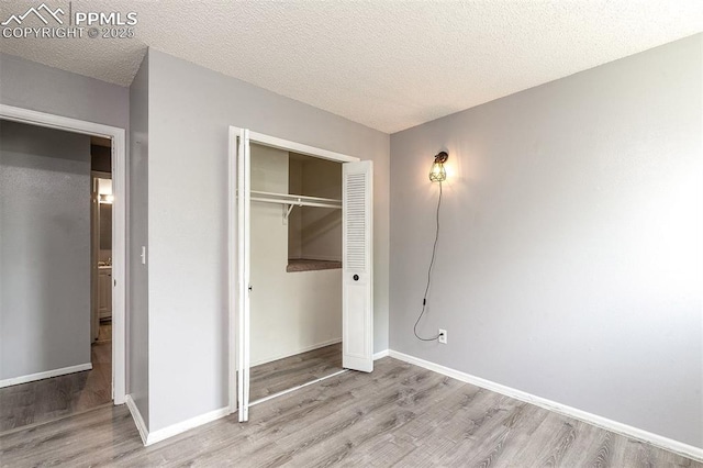 1950 Rusty Hinge Dr, Colorado Springs, CO 80920 - unfurnished bedroom with wood finished floors, a closet, baseboards, and a textured ceiling
