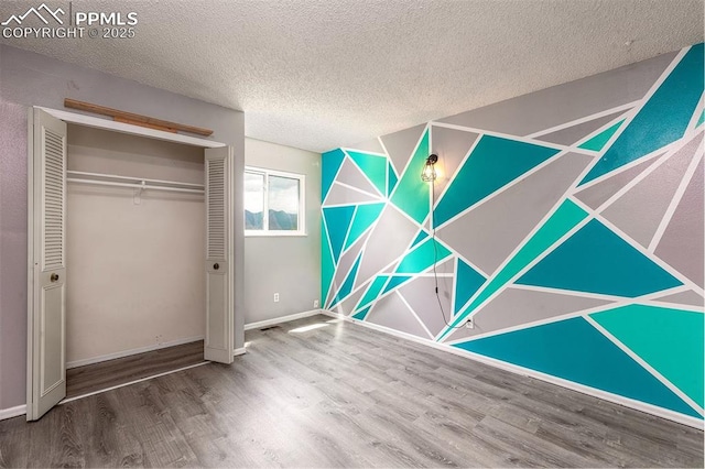 1950 Rusty Hinge Dr, Colorado Springs, CO 80920 - unfurnished bedroom featuring wood finished floors, a textured ceiling, a closet, and baseboards