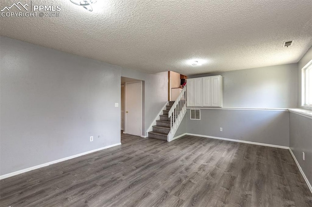1950 Rusty Hinge Dr, Colorado Springs, CO 80920 - unfurnished room with dark wood-style floors, stairway, baseboards, and a textured ceiling