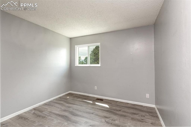1950 Rusty Hinge Dr, Colorado Springs, CO 80920 - empty room featuring wood finished floors, baseboards, and a textured ceiling