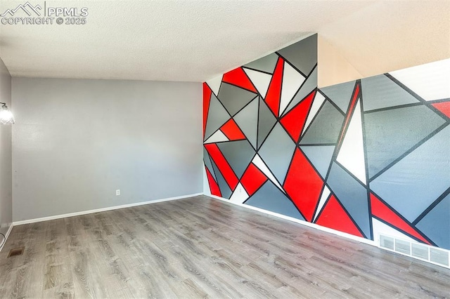 1950 Rusty Hinge Dr, Colorado Springs, CO 80920 - spare room with wood finished floors, an accent wall, baseboards, and a textured ceiling