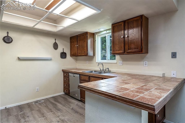 1950 Rusty Hinge Dr, Colorado Springs, CO 80920 - kitchen featuring dishwasher, a sink, light wood-style floors, a peninsula, and baseboards
