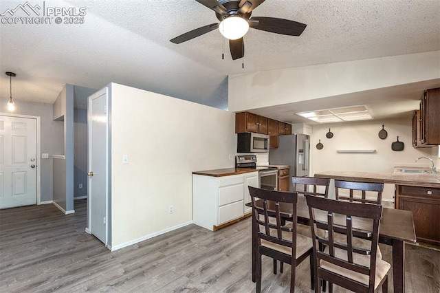 1950 Rusty Hinge Dr, Colorado Springs, CO 80920 - dining area with wood finished floors, a ceiling fan, vaulted ceiling, baseboards, and a textured ceiling