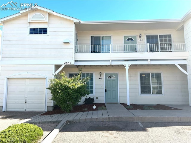 multi unit property with an attached garage and a balcony