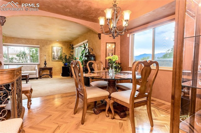 1522 Lehmberg Blvd, Colorado Springs, CO 80915 - dining area with arched walkways, a chandelier, a mountain view, and a textured wall