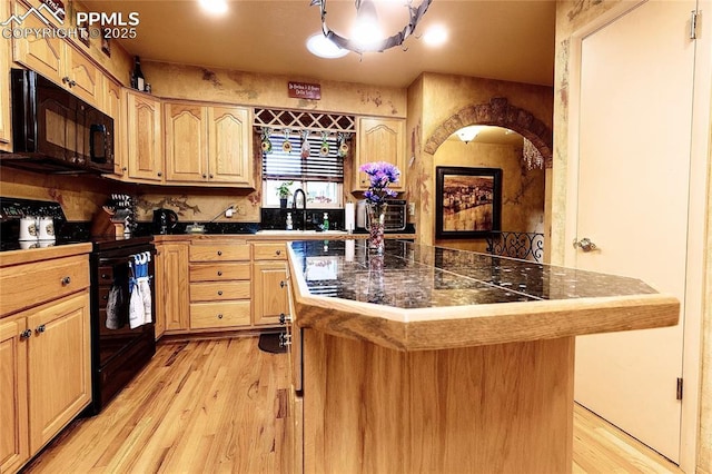 1522 Lehmberg Blvd, Colorado Springs, CO 80915 - kitchen with black appliances, light wood-style floors, a kitchen island, and light brown cabinets