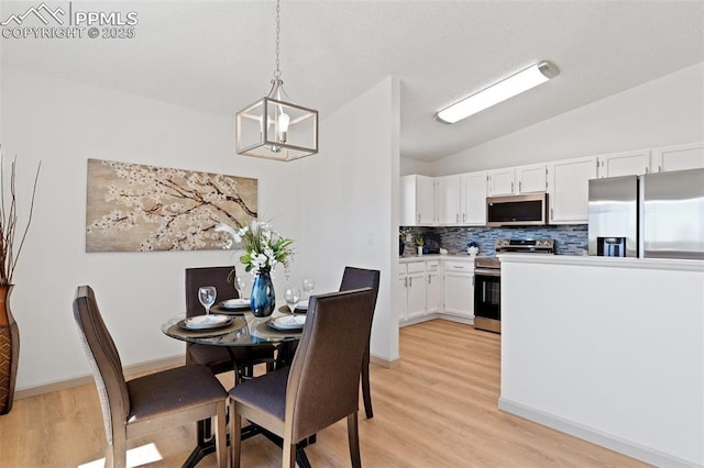 929 Bromefield Dr, Fountain, CO 80817 - dining space with baseboards, vaulted ceiling, light wood-type flooring, and a notable chandelier
