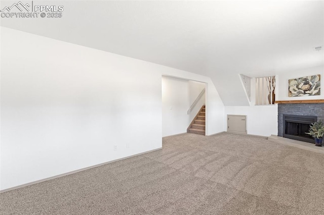 929 Bromefield Dr, Fountain, CO 80817 - unfurnished living room with a fireplace with raised hearth, carpet, vaulted ceiling, and stairway