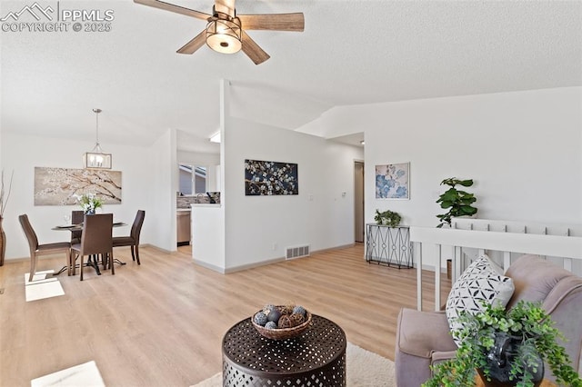 929 Bromefield Dr, Fountain, CO 80817 - living room with visible vents, light wood-type flooring, a textured ceiling, a ceiling fan, and vaulted ceiling