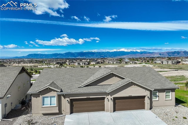 9484 Simper Hts, Colorado Springs, CO 80924 - view of front of home featuring stucco siding, an attached garage, roof with shingles, a mountain view, and driveway