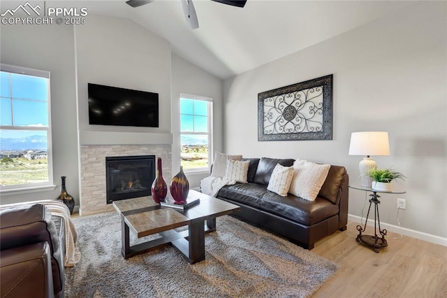 9484 Simper Hts, Colorado Springs, CO 80924 - living room with lofted ceiling, ceiling fan, wood finished floors, a stone fireplace, and baseboards