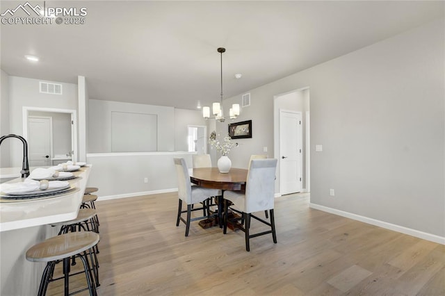9484 Simper Hts, Colorado Springs, CO 80924 - dining area with a chandelier, light wood-style flooring, and baseboards